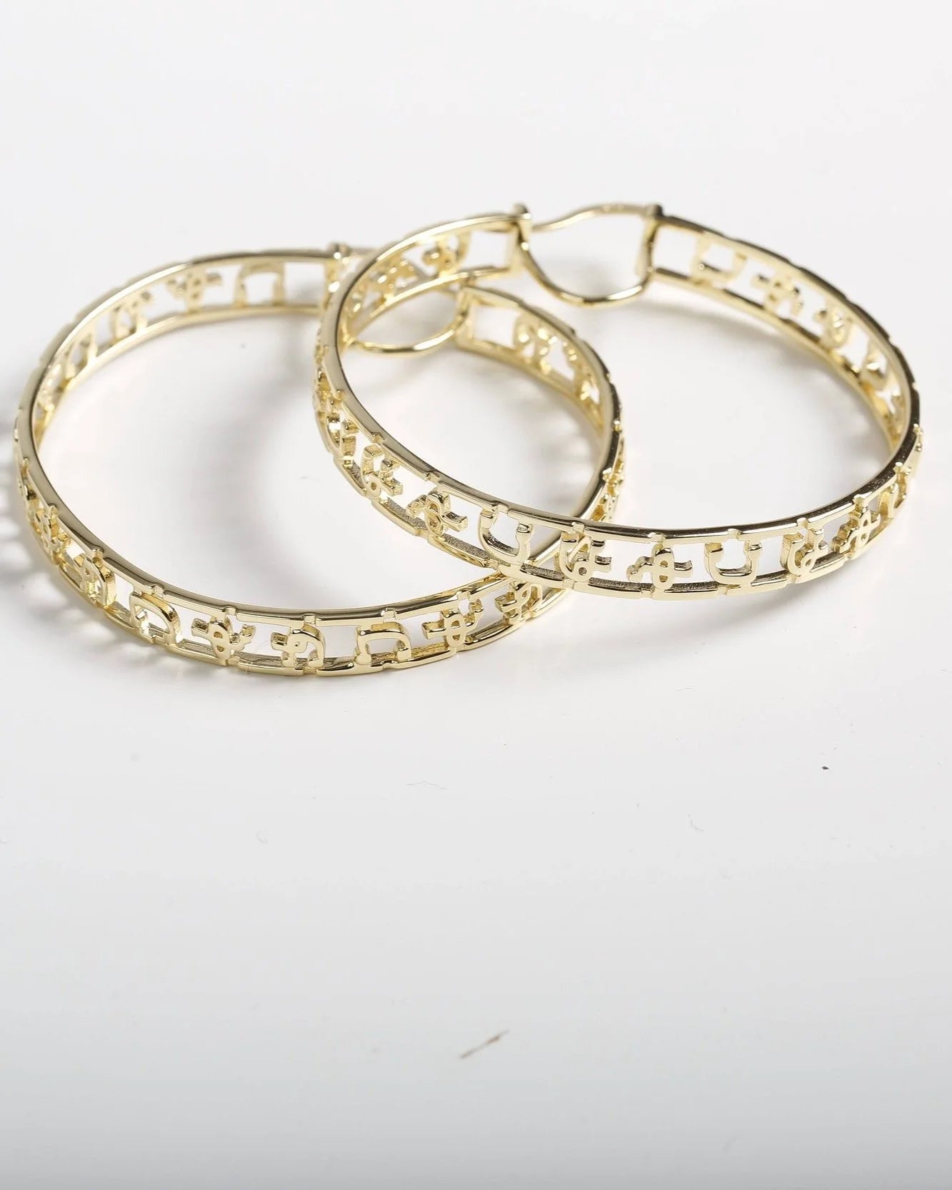 Hawi Yema Fikir hoop earrings in 14k gold-plated sterling silver with carved Amharic alphabet and 2.2-inch diameter