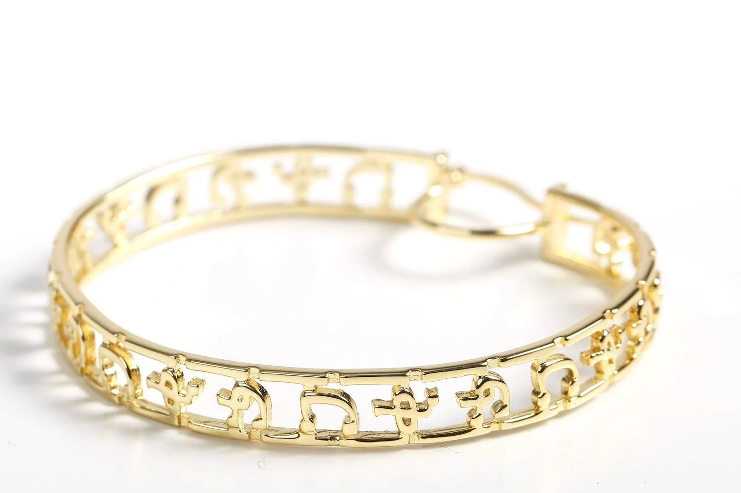 Close-up of Ethiopian Amharic script hoops showing premium gold plating and detailed letter carving