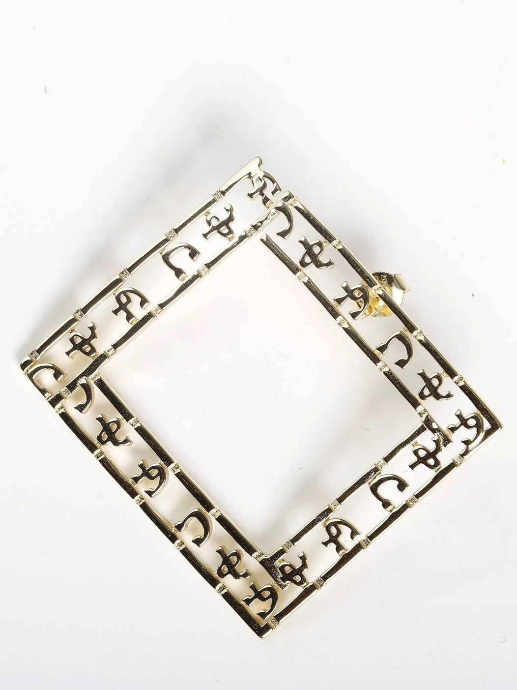 Close-up of Ethiopian Amharic script earrings showing premium gold plating and detailed letter carving