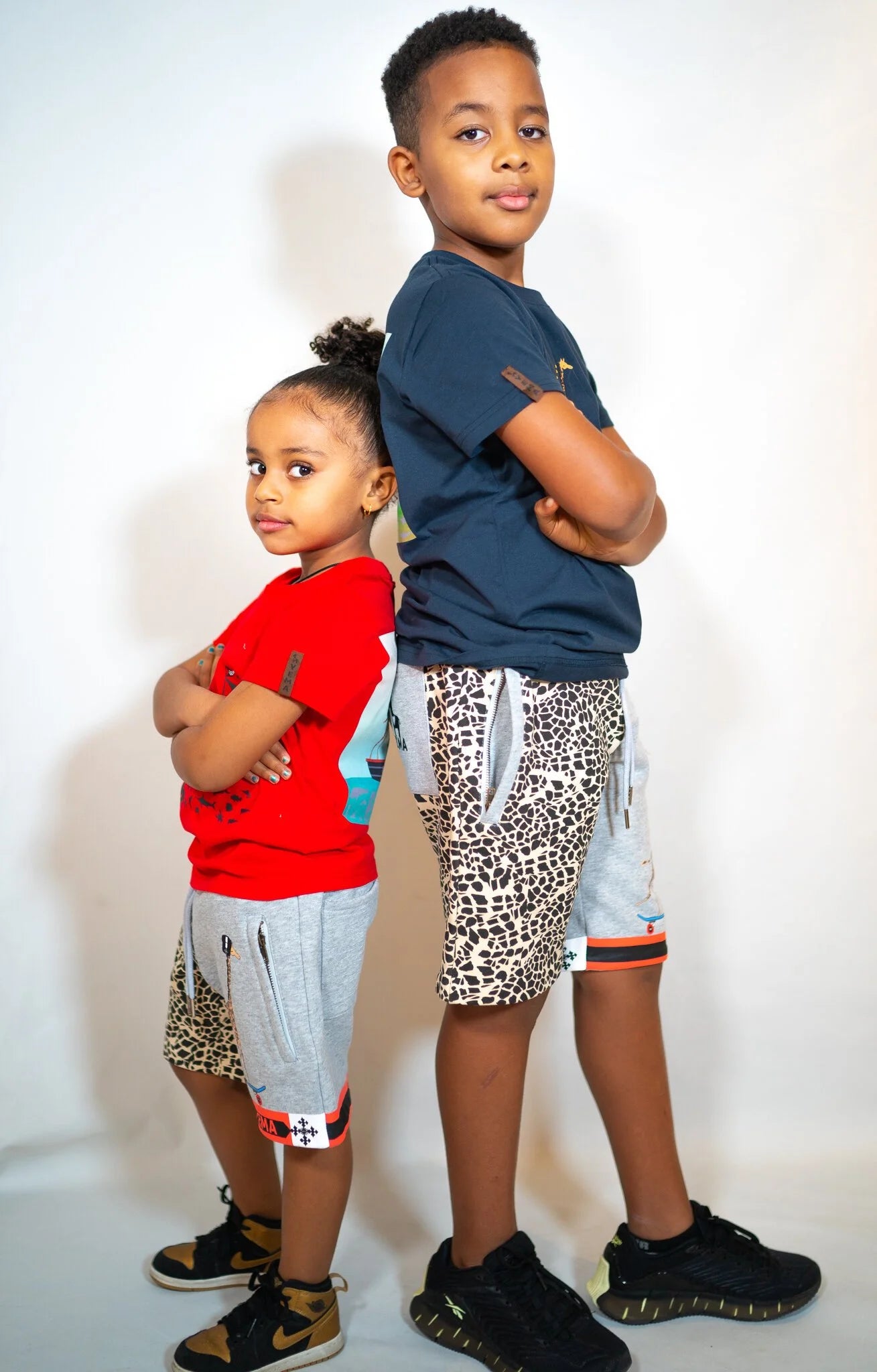 Side view of kids' designer shorts with meskel-inspired details in warm Clay colorway