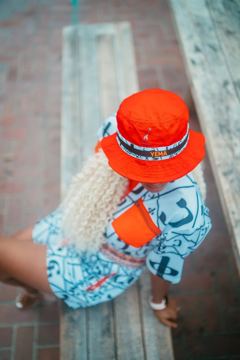 Top view of bucket hat honoring Abebe Bikila with iconic YEMA giraffe skating motif