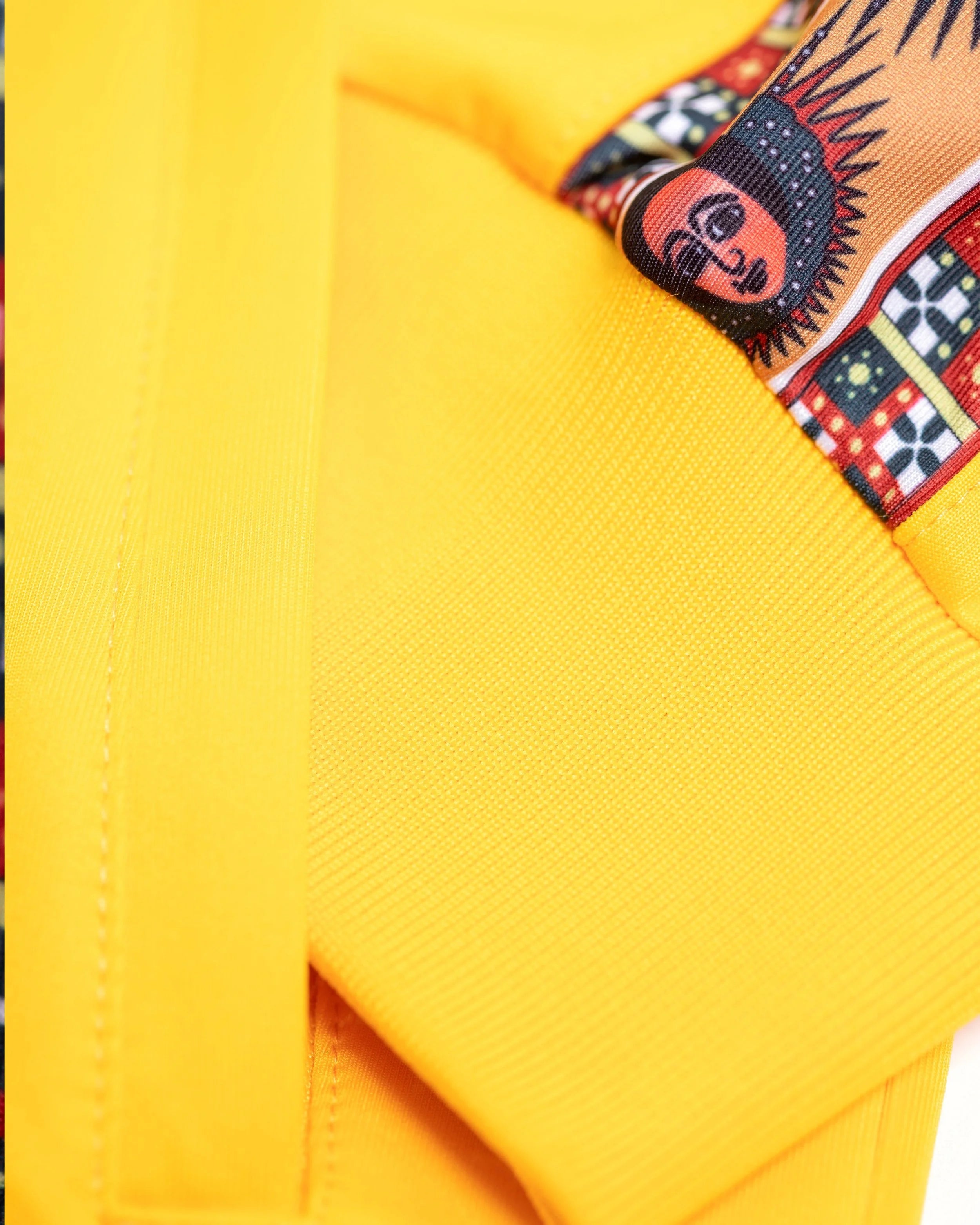 Close-up of track jacket displaying sacred Abyssinian angels representing love peace and victory