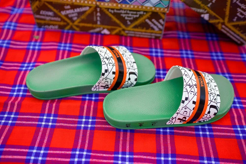 YEMA FIKIR slides in Addis Green featuring Amharic love pattern and signature orange black stripes