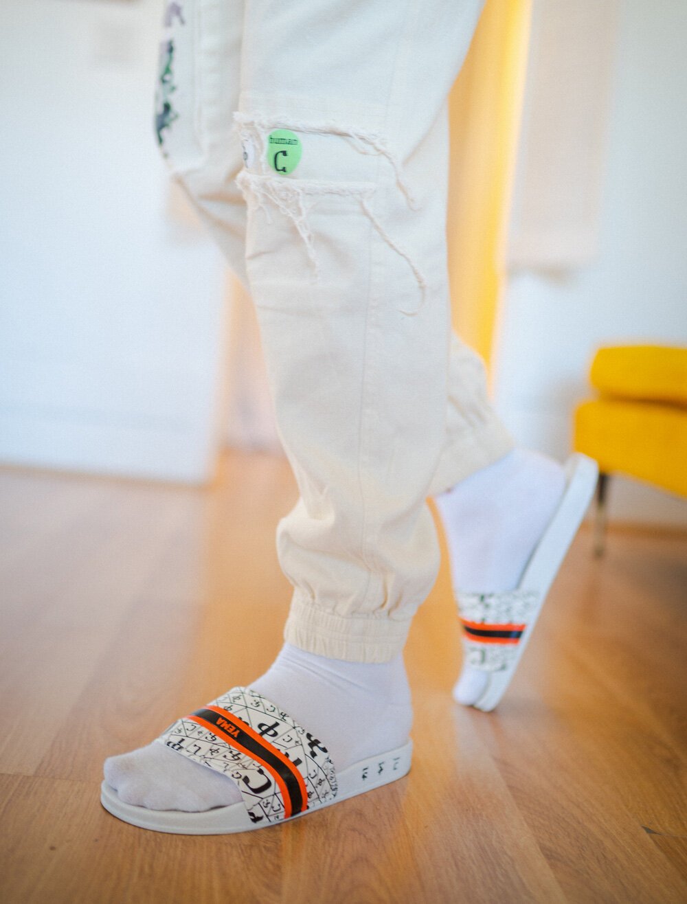 YEMA FIKIR slides classic white colorway with ancient Ethiopian language pattern across strap