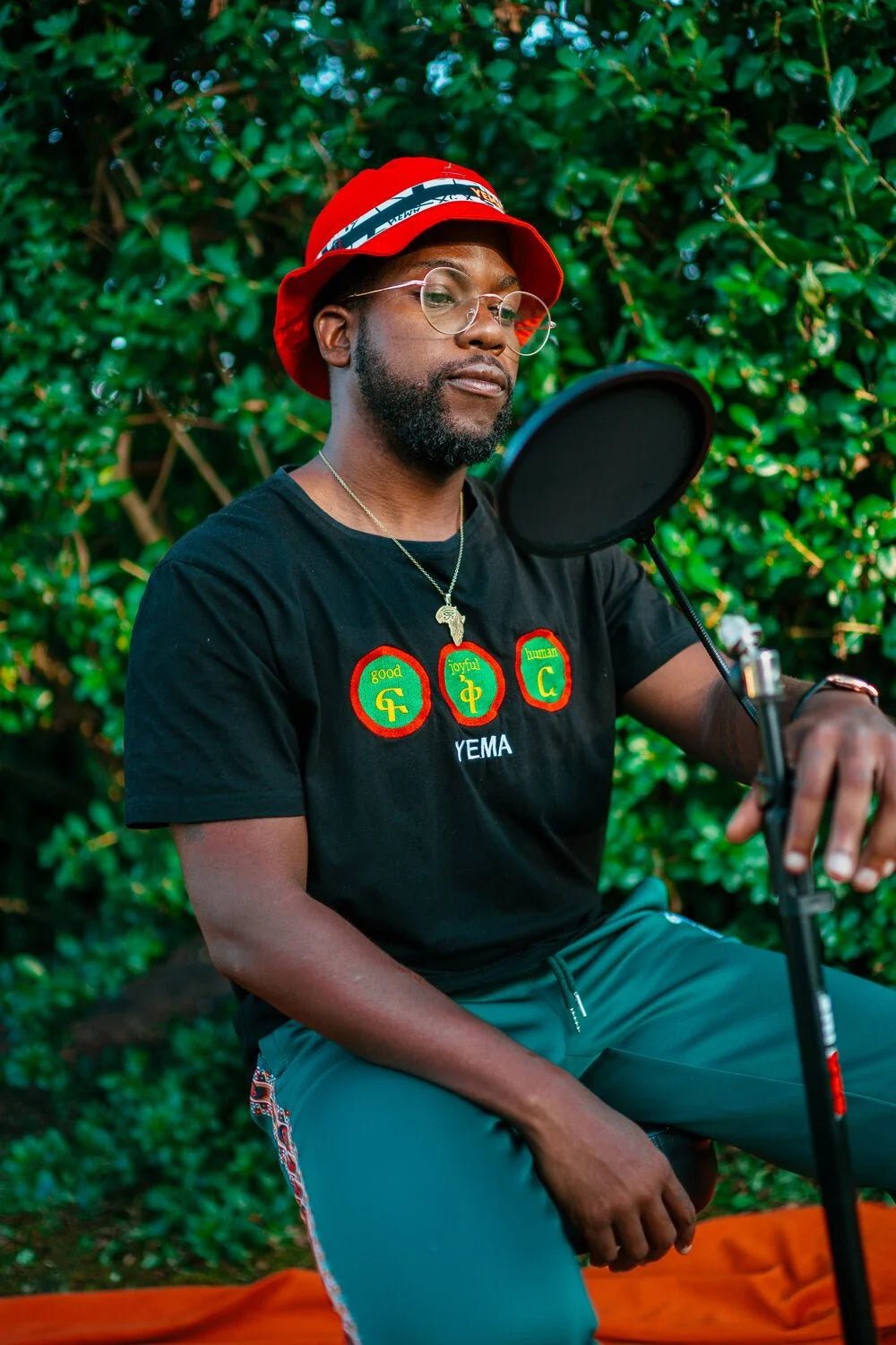 Front view of Addis Black cotton tee showing fikir-inspired embroidered logo detail