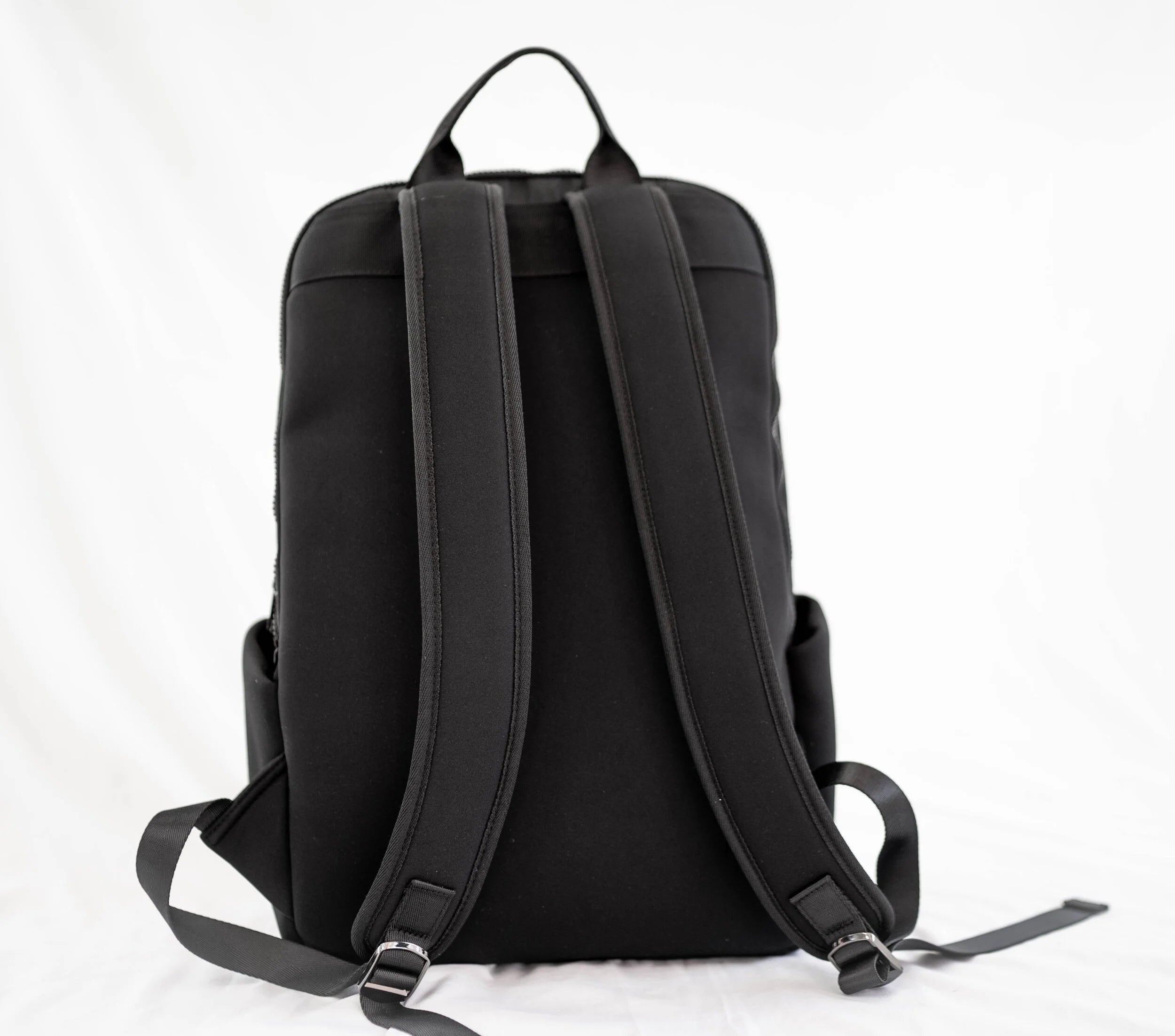 YEMA HY Lux Backpack in black neoprene with round leather pockets featuring Ethiopian Amharic lettering