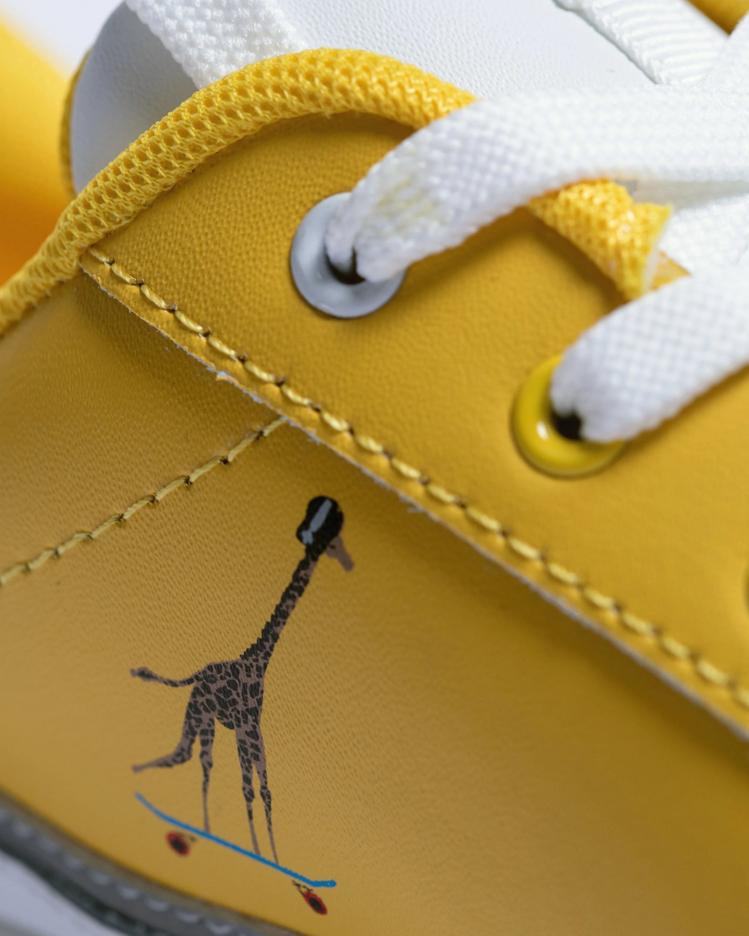 Detail of genuine leather construction with padded collar and comfortable insoles in bright yellow