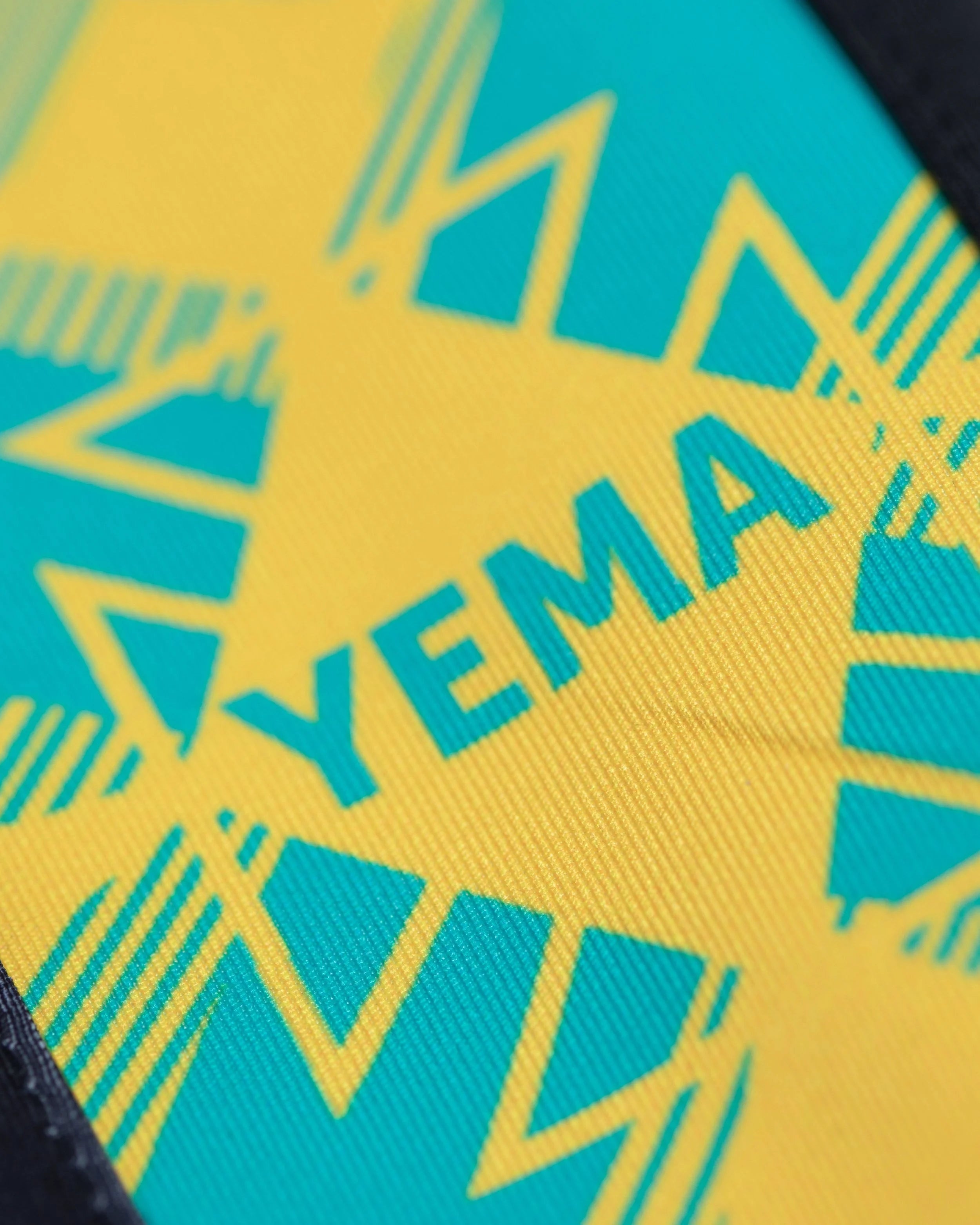 Detail of YEMA pants displaying Amharic alphabet design and woven polyester construction