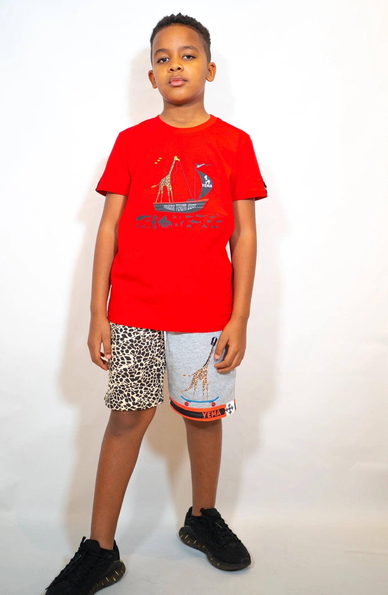 Front view of kids' tee with Captain Giraffe graphic in Lali Red colorway honoring Lalibela