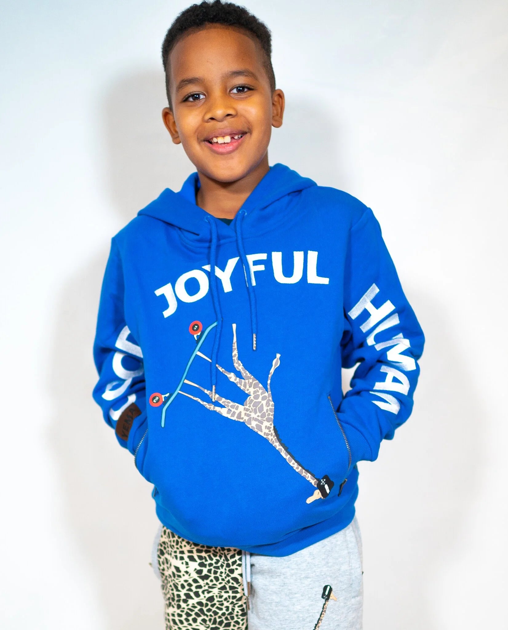 Child wearing Kibera Blue hoodie showing full frontal GJH embroidery and vintage zipper pockets