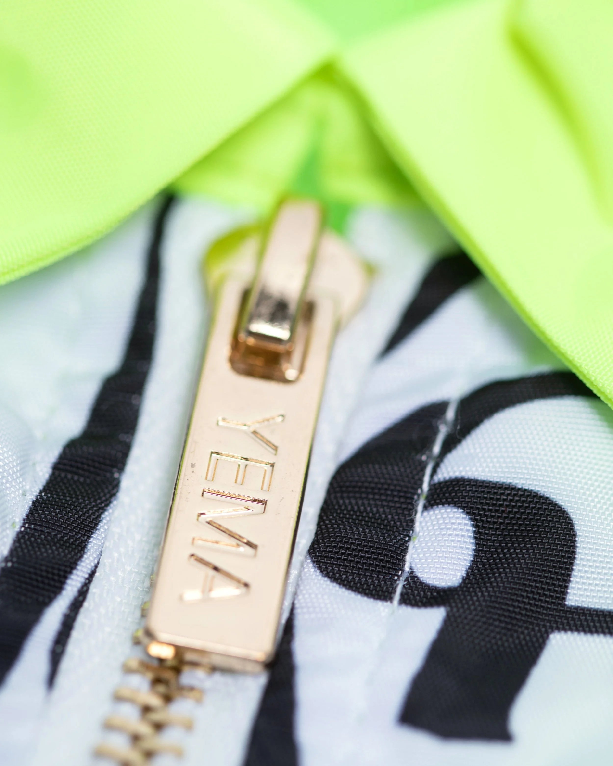 Close-up of YEMA vest featuring color-blocked purple pockets and premium gold hardware