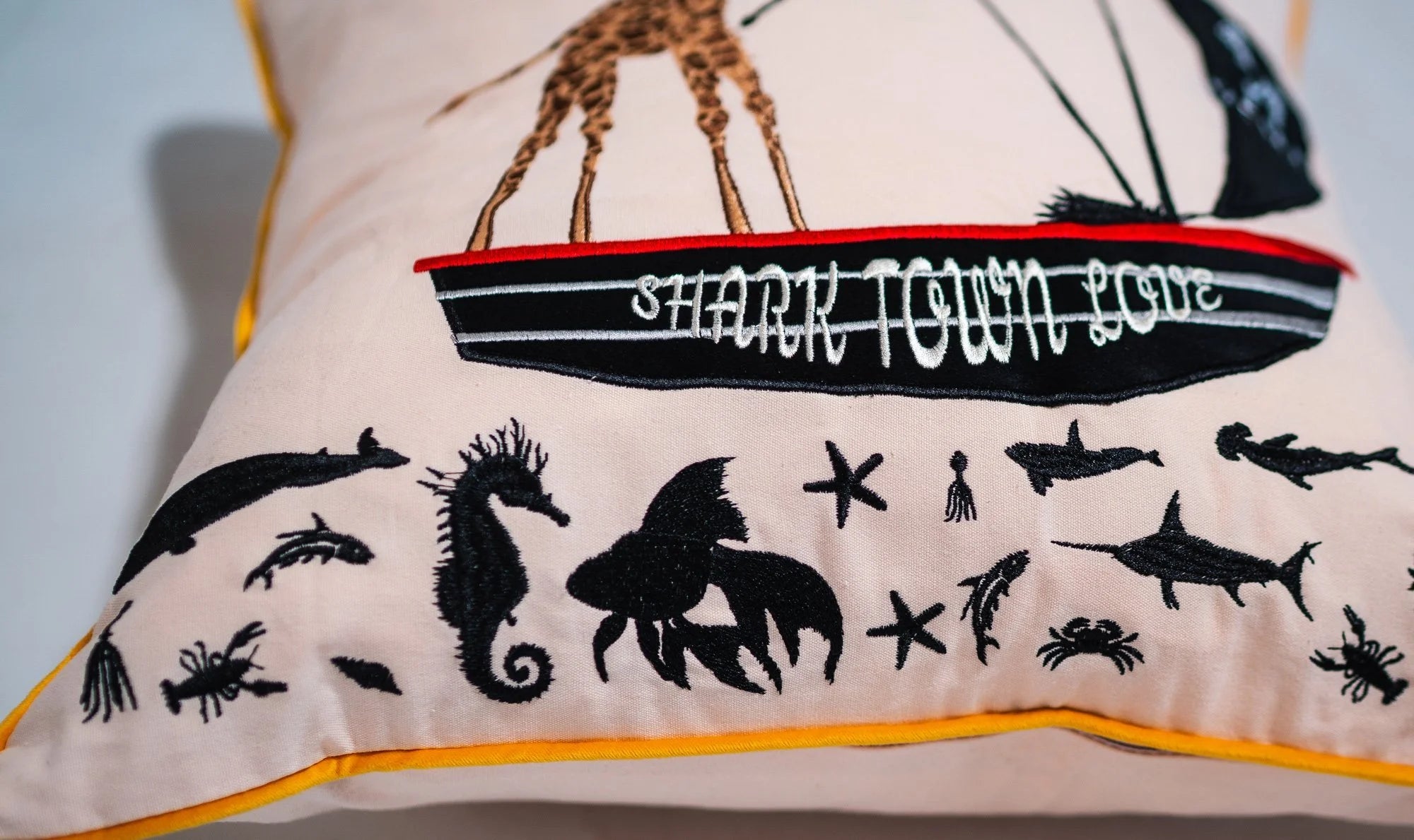 Close-up of embroidered Captain Giraffe design with gold-colored velvet trim detail